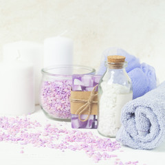 Fototapeta na wymiar Bath salt, towel, sponge on a gentle purple background. Beauty and body care concept. Selective focus. Horizontal frame.