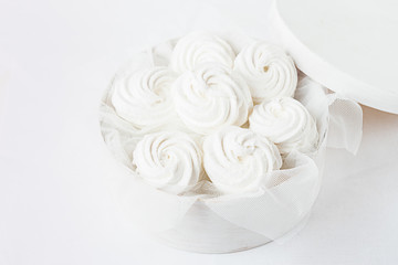 White marshmallow in a white box on a light background. Horizontal frame. Selective focus