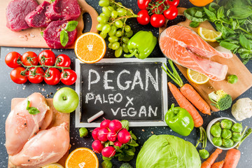Trendy pegan diet - vegan plus paleo diet food concept, many fresh vegetables, fruits, raw beef and...