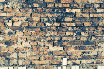 old bare wall with dirty cracked brickwork of brown bricks