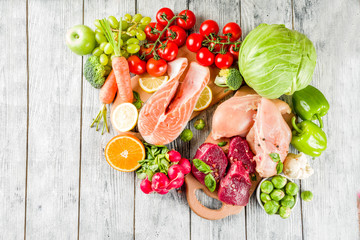 Trendy pegan diet - vegan plus paleo diet food concept, many fresh vegetables, fruits, raw beef and...