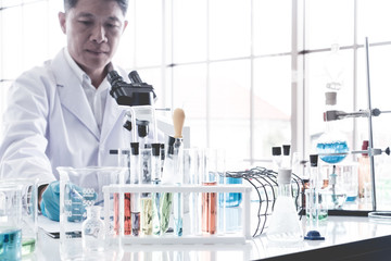 Scientist doing some research and looking through a microscope in a laboratory