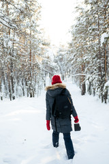 Fototapeta na wymiar The girl in the red hat in the winter forest