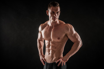 Fototapeta na wymiar Athletic shirtless young male fitness model posing