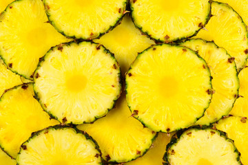 Pineapple juicy yellow slices background. Top view.