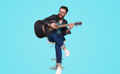 Trendy man with guitar on stool 