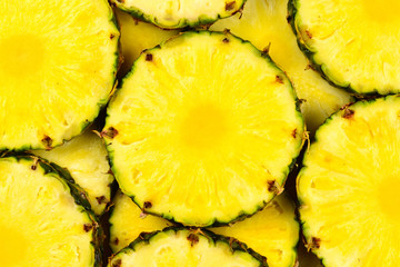 Pineapple juicy yellow slices background. Top view.