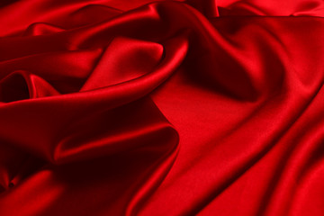 Red silk or satin luxury fabric texture can use as abstract background. Top view.