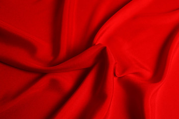 Red silk or satin luxury fabric texture can use as abstract background. Top view.