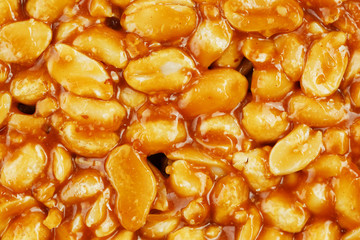 Kozinaki from golden, roasted peanuts beans as a background, texture. Macro shooting, close-up. Place for text