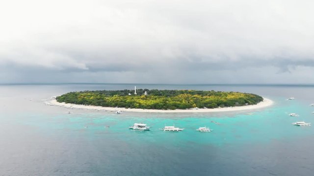 Aerial footage of Balicasag Island in Philippines. Stunning view on coral reef and circle island. Panglao, Bohol, white beach, palm trees, boats / 4K Drone Video