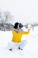 Fototapeta na wymiar beautiful girl with black hair and yellow sweater with virtual glasses outdoor in the snow