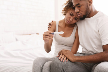 Black couple with a negative pregnancy test result - obrazy, fototapety, plakaty