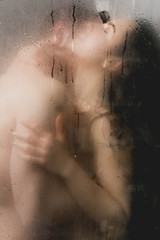 selective focus of sexy couple hugging and kissing in shower cabin