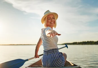 Foto op Canvas Smiling young woman enjoying a sunny day canoeing in summer © Flamingo Images