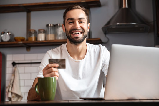 Happy young man using laptop computer
