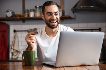 Happy young man using laptop computer