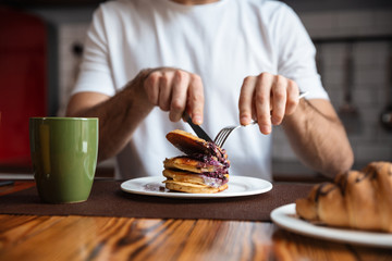 Fototapeta na wymiar Close up of a man having pancakes for breakfast
