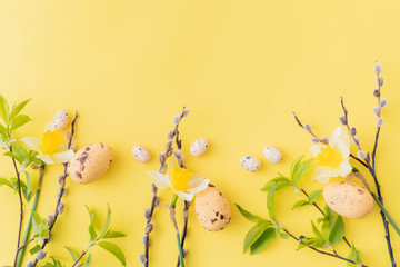 Flat lay easter composition with yellow daffodils and eggs on a yellow background