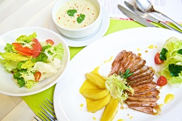 duck slices with pear slices and salad