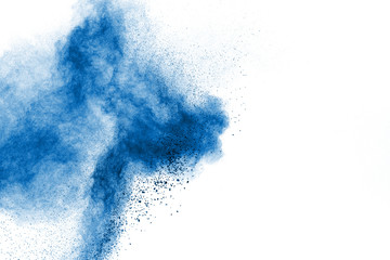 Abstract blue dust explosion on white background. Freeze motion of blue particles splashing. Painted Holi in festival.