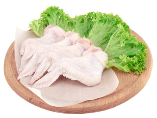 Raw chicken wings on wooden cutting board isolated on white background