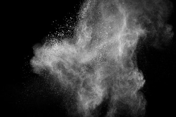 White powder explosion cloud against black background.White dust particles splash.