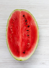 Fresh cut watermelon on a white wooden table, top view. From above, overhead. Close-up.