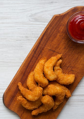 Overhead view, fried shrimps tempura with sauce on wooden board over white wooden table. Close-up.