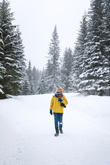 Photoigrapher on the road in winter forest