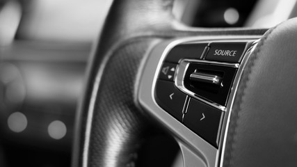 multifunction buttons for quick control at a black steering wheel.