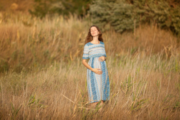 beautiful sweet pregnant woman walking in nature