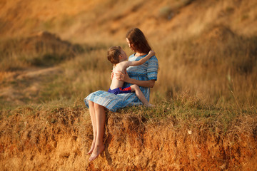 beautiful pregnant woman walking on nature with a child