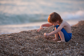 cute baby boy playing at the sea