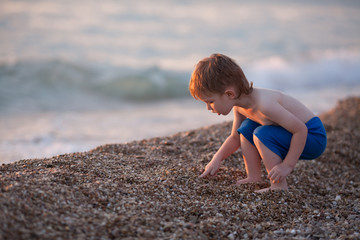 cute baby boy playing at the sea
