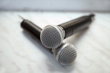 Obraz premium Two silver microphones isolated over white background . Two wireless microphones on the conference table.