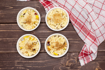 Uncooked chopped mixed fruits. recipe step by step crumble with fruits in a ceramic ramekin flatlay on brown wood