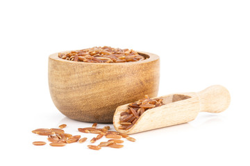 Closeup of lot of whole raw red rice with wooden bowl isolated on white background