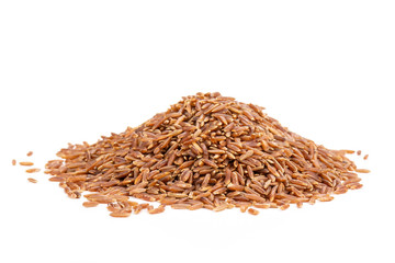 Lot of whole raw red rice stack isolated on white background