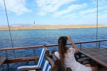 young girl looks at the blue sea