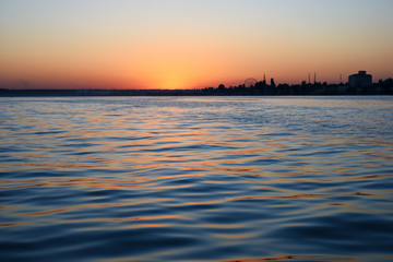 sunset over the calm black sea with seagulls