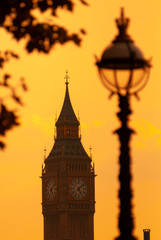 Fototapeta na wymiar Silhouette of The Elizabeth Tower or Big Ben next the Houses of Parliament against a orange evening sky