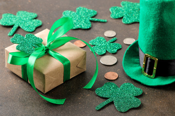 St.Patrick 's Day. celebration. Green leprechaun hat, money and clover leaf and gift box on brown...