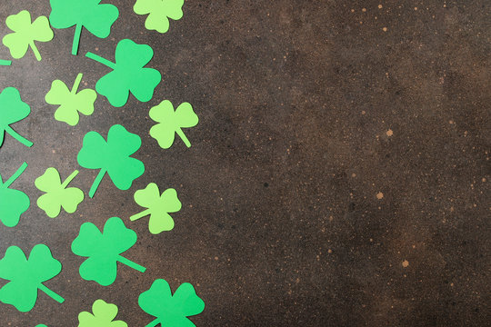 St.Patrick 's Day. Holiday. Frame of green leaves of clover on a brown background. top view. space for text