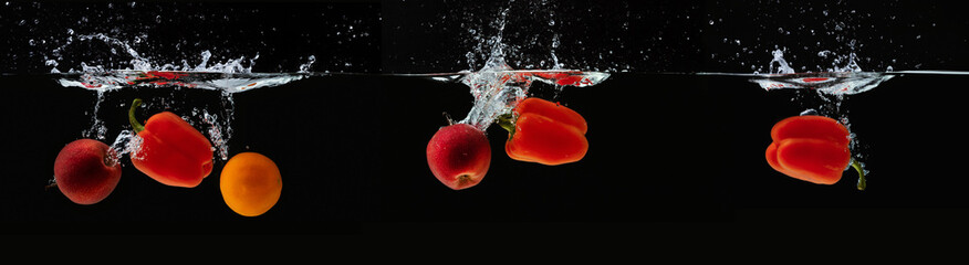 Fresh apple, orange and pepper water splash on black © Prostock-studio