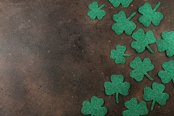 St.Patrick 's Day. Holiday. Frame of green leaves of clover on a brown background. top view. space for text