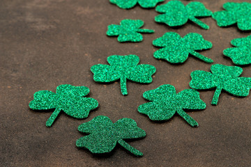 St.Patrick 's Day. celebration. clover green leaflets closeup on brown background.