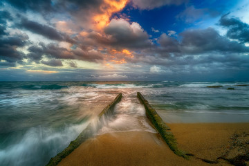 Dramatic sunrise low hanging clouds over wavy blue ocean at San Juan, Peurto Rico
