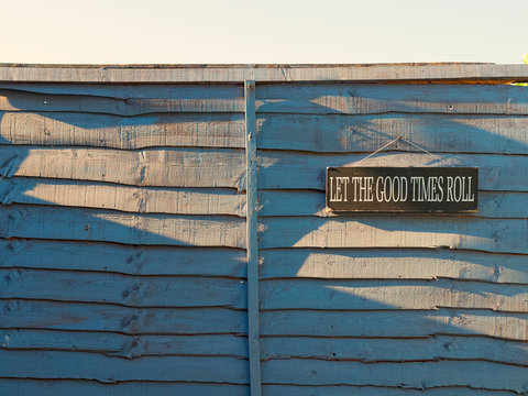 Let The Good Times Roll Sign hanging on a fence