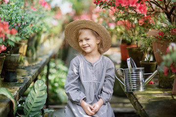 Toddler with flower basket. girl holding pink flowers